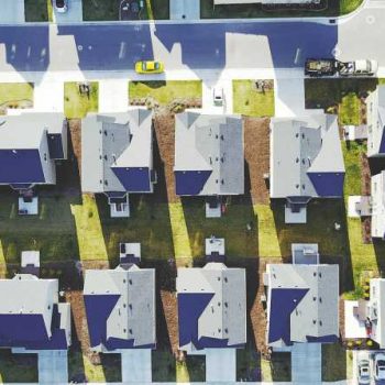 An aerial photo depicts a gridded suburb as seen from above.