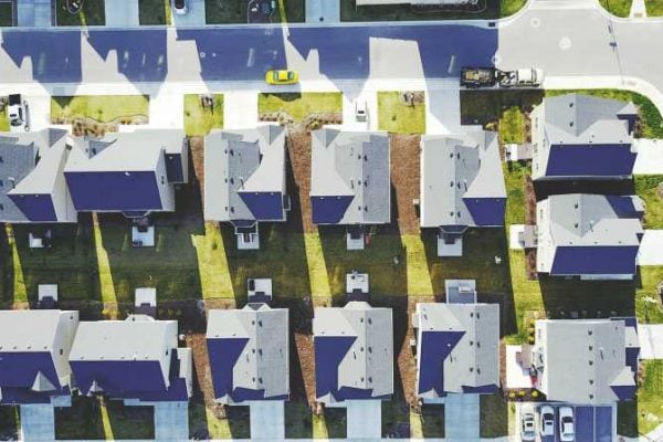 An aerial photo depicts a gridded suburb as seen from above.