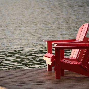 Red lawn chairs on deck overlooking lake