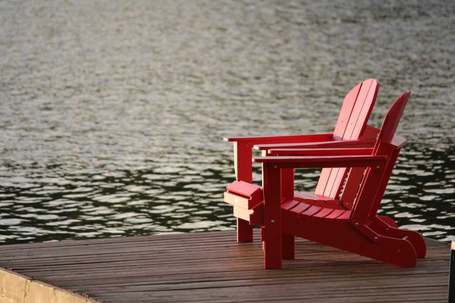 Red lawn chairs on deck overlooking lake