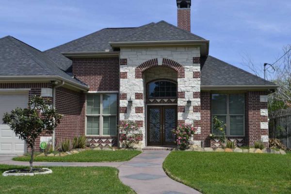 Green, curated lawn leading to front door behind two columns. - Real Estate San Marcos TX