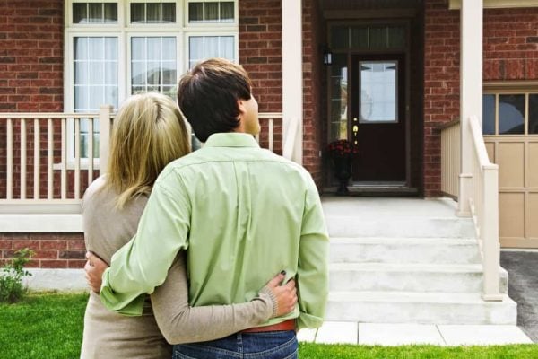 Happy couple in front of home