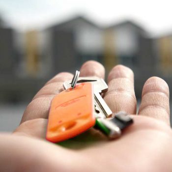 A hand presenting a new set of house keys