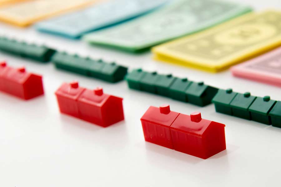 Monopoly houses and money laid out in a row