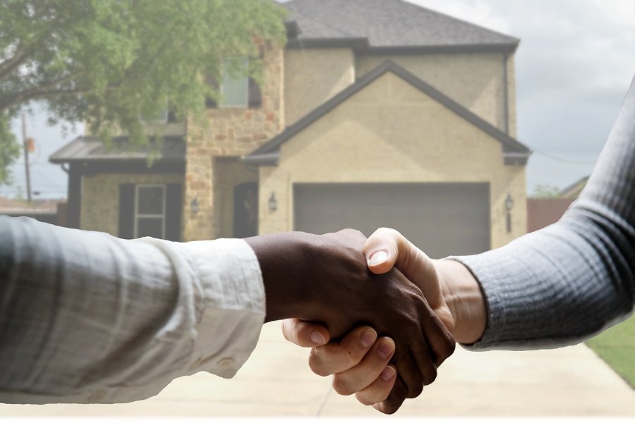 Handshake with real estate agent in front of home