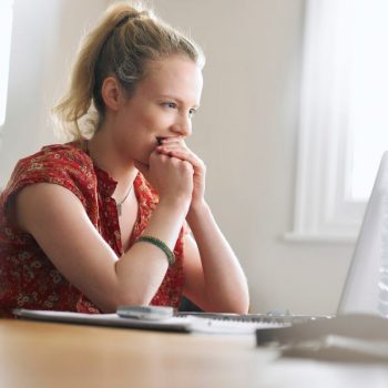 Excited woman looking at laptop