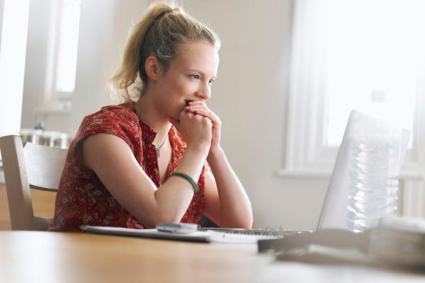 Excited woman looking at laptop