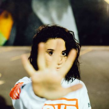 Woman with open hand raised indicating "stop"