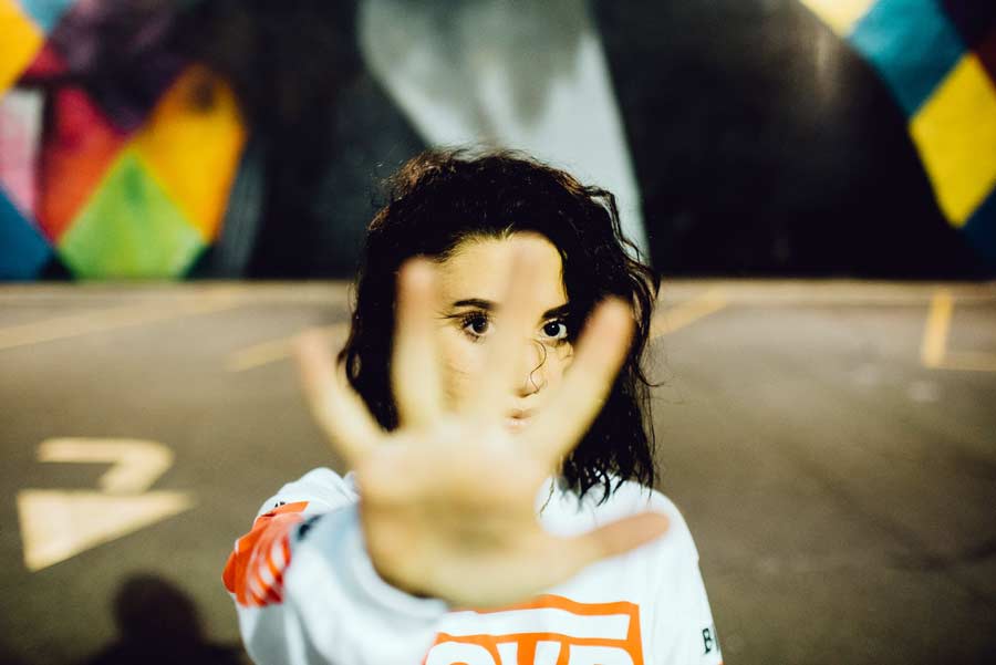 Woman with open hand raised indicating "stop"