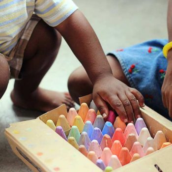 children playing with chalk on a driveway