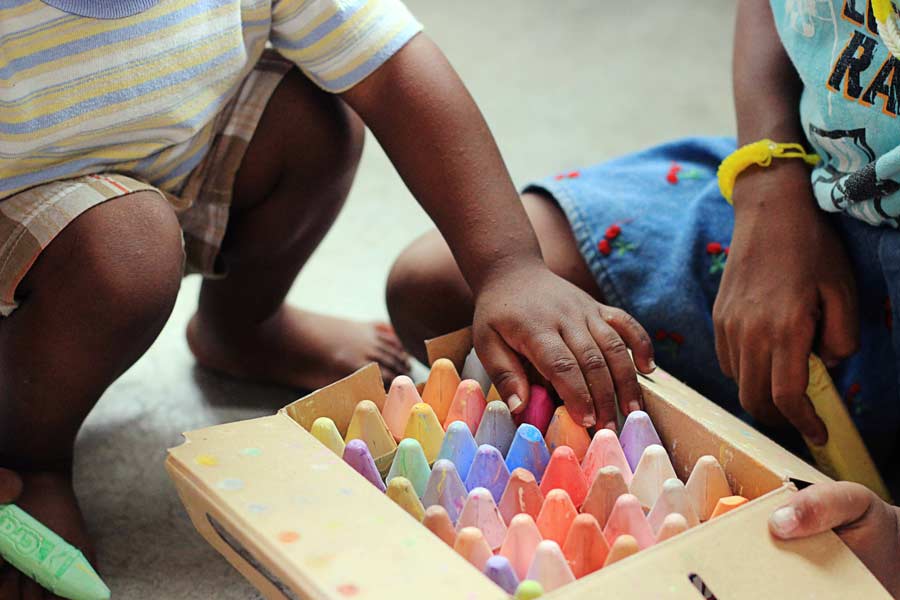 children playing with chalk on a driveway