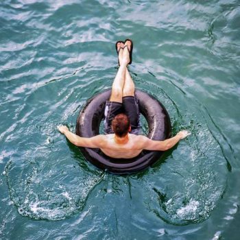 Man floating down the San Marcos river on a tube