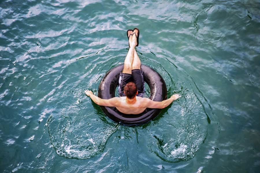 Man floating down the San Marcos river on a tube