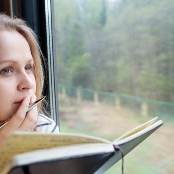 woman brainstorming while writing a letter in her journal