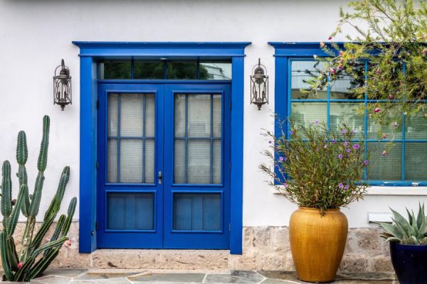 cool house with grecian blue door and container garden in the front